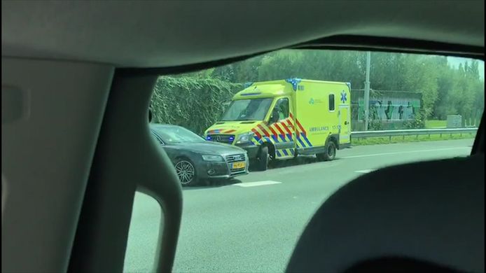 Een ongeduldige automobilist blokkeert een ambulance met zwaailicht en sirene.
