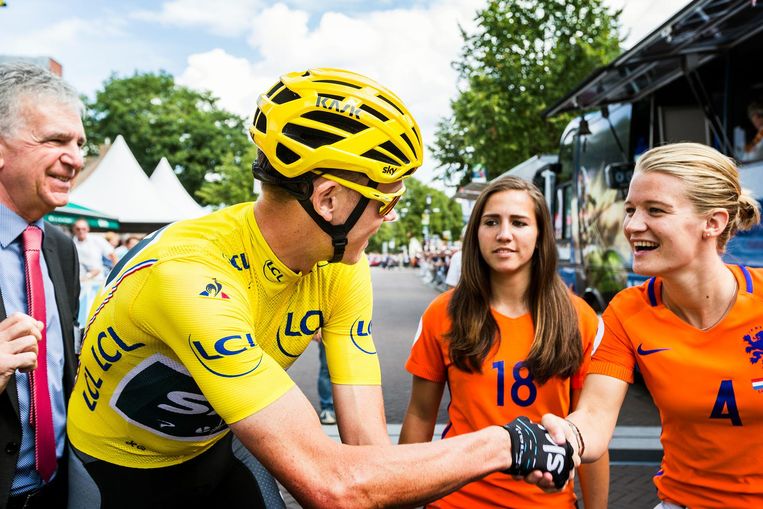 Voetballers Mandy van den Berg en Vanity Lewerissa van het Nederlands elftal begroeten de Tourwinnaar. Beeld Jiri Buller / de Volkskrant