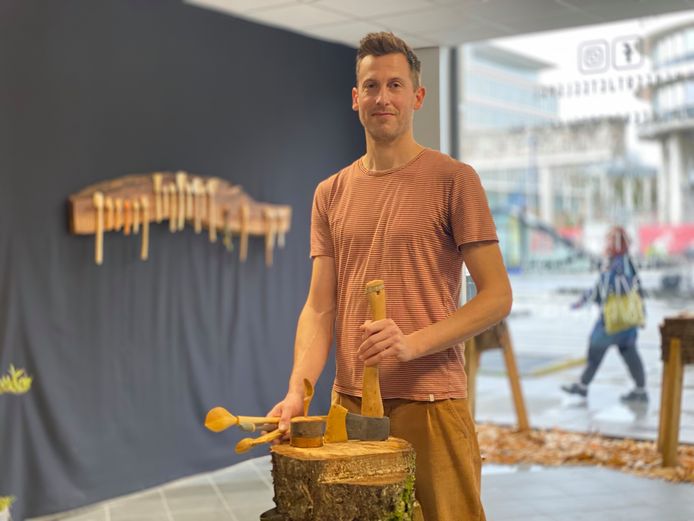 Thomas Reyntens in zijn pop-up winkel met op de achtergrond zelfgemaakte, houten lepels.