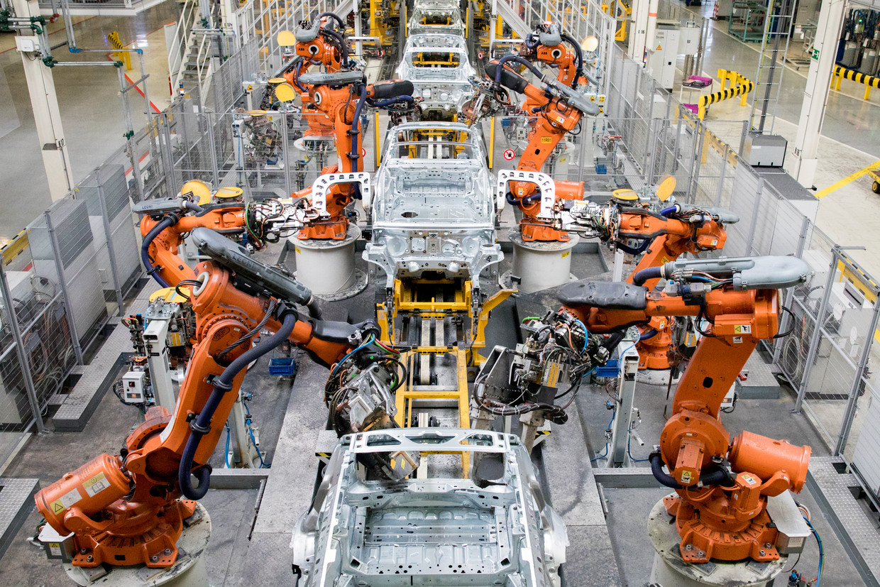 Robots aan een assemblagelijn bij autofabrikant VDL Nedcar in Born. Grote Nederlanse industriële bedrijven kunnen de prijsstijgingen in de markt doorberekenen aan hun afnemers. Maar voor kleinere leveranciers is dat veel lastiger. Beeld ANP