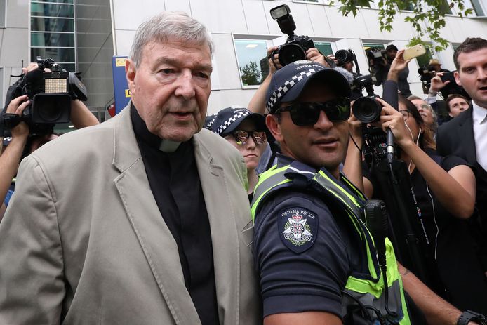 Omstuwd door cameraploegen verlaat George Pell de rechtbank in Melbourne.