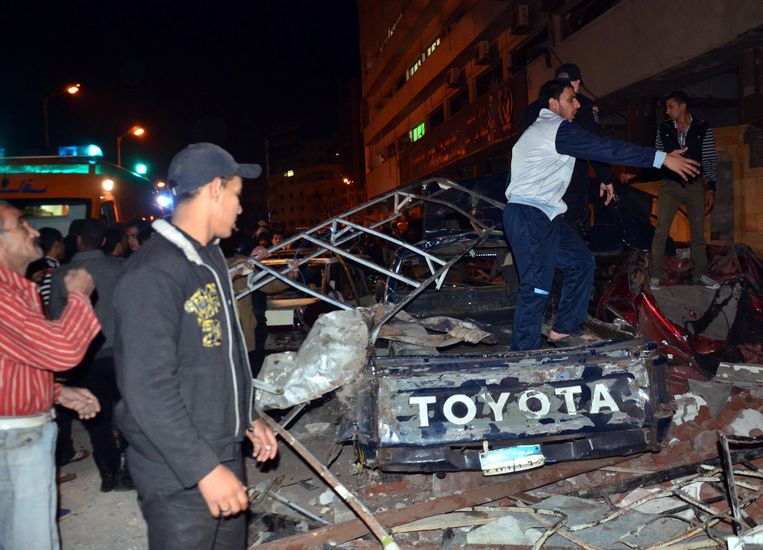 Een autowrak bij het gebouw in Mansoura dat het doelwit was van een aanslag. Beeld EPA