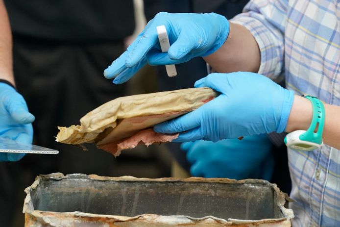 Conservator Sue Donovan van de University of Virginia haalt een boek uit de loden tijdscapsule die in Richmond in de sokkel van het standbeeld van de omstreden generaal Lee werd gevonden.