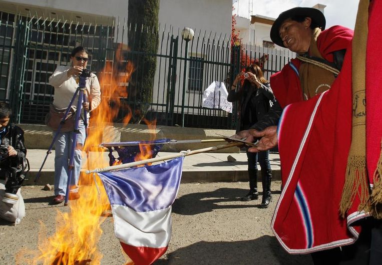Boliviaanse demonstranten verbrandden Franse en Europese vlaggen voor de Franse ambassade in La Paz. Beeld reuters