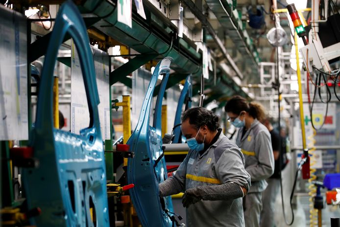 Renault-medewerkers met mondmaskers aan het werk in de fabriek van Flins in de omgeving van Parijs. Het is de grootste vestiging van het Franse automerk.