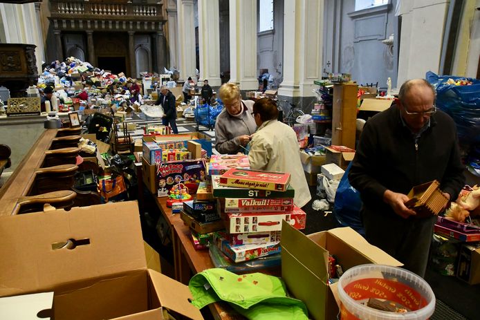 In de kerk van het Grootseminarie in Brugge zijn enkele tientallen vrijwilligers aan de slag om alle ingezamelde hulpgoederen te sorteren, om eind januari vijf vrachtwagens vol bruikbare spullen naar Trooz te kunnen sturen.