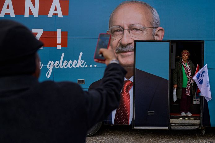 Een Turkse kiezer poseert bij een bus van presidentskandidaat Kemal Kilicdaroglu. Zowel Erdogan als Kilicdaroglu staan in de peilingen op 45%.