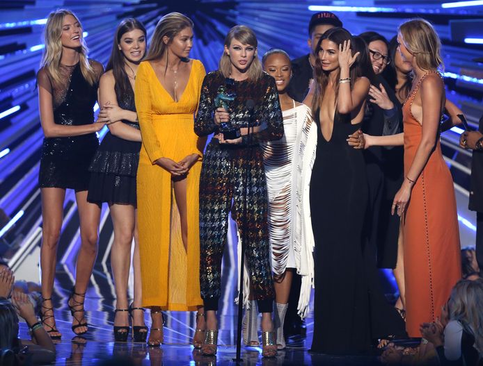 Gigi Hadid (in gele jurk), mocht mee het podium op met Taylor Swift (in het midden).