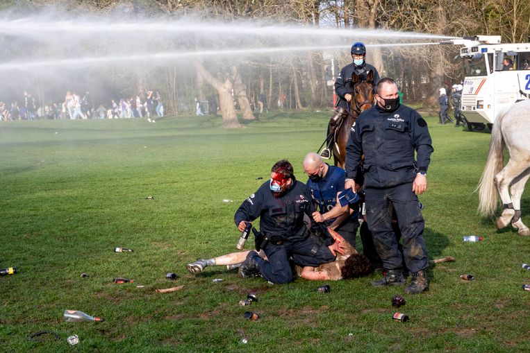Een gewonde agent arresteert een relschopper tijdens het nepfestival La Boum in het Brusselse Ter Kamerenbos, april 2021.  Beeld BELGA