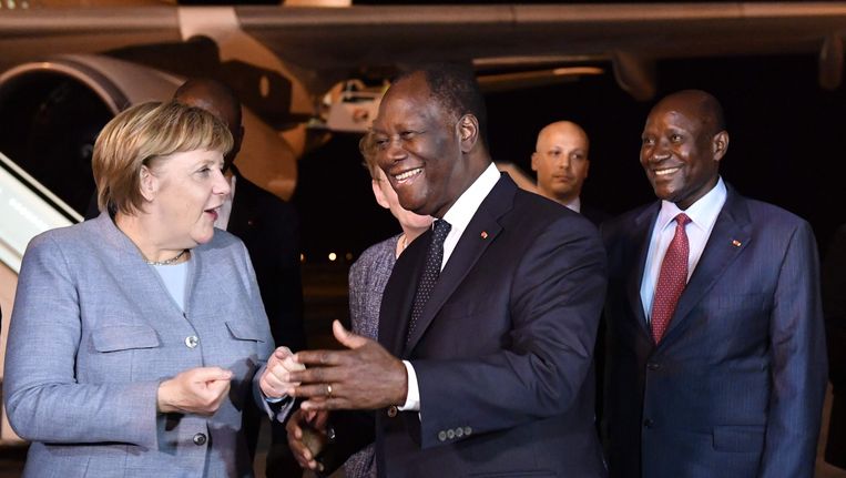 De Duitse bondskanselier Angela Merkel wordt opgehaald op het vliegveld van Abidjan door de Ivoriaanse president Alassane Ouattara. Beeld afp