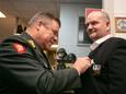 Kolonel Ludy de Vos, directeur van het Veteranen Instituut in Doorn, speldt het DIG op de revers van Michel Noppers.