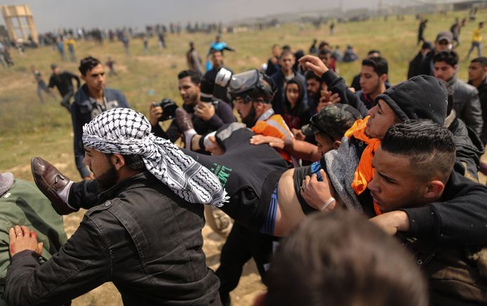 Een Palestijnse betoger wordt weggedragen nadat hij gewond raakte tijdens schermutselingen met Israëlische soldaten.