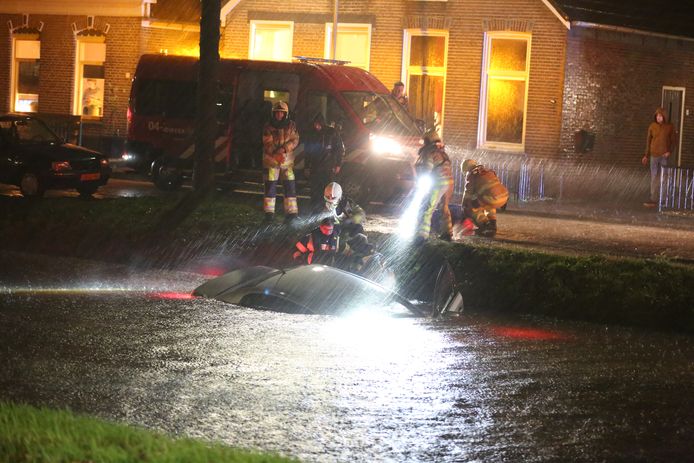 Hulpdiensten bij de auto die in de Hoofdvaart belandde in Dedemsvaart.