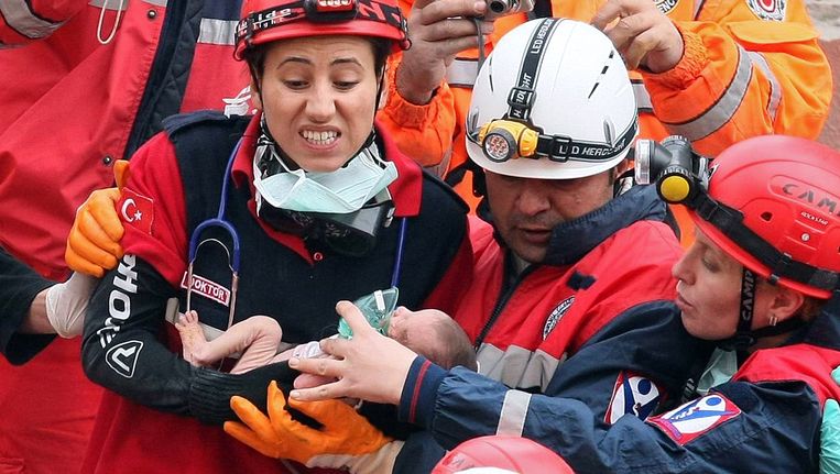 Een baby wordt gered uit de puinhopen van een pand in de zwaargetroffen stad Ercis. Beeld AFP