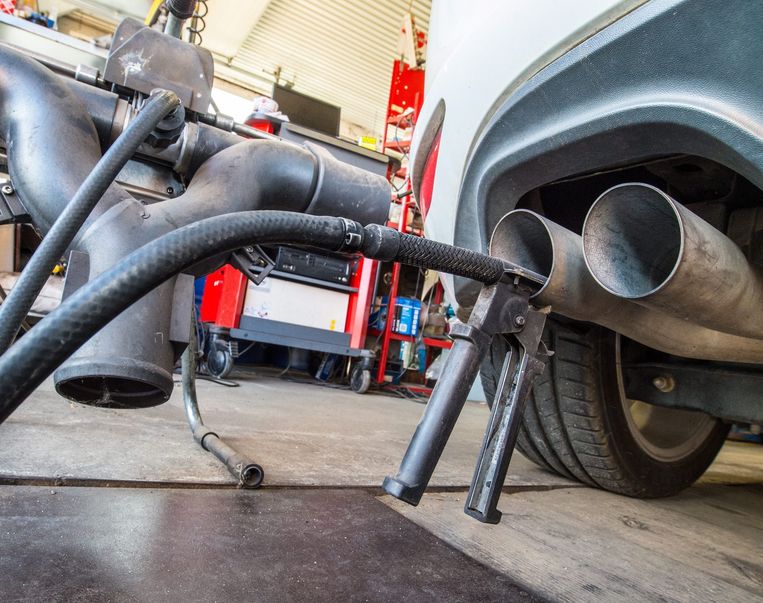 Een apparaat waarmee de CO2-uitstoot kan worden getest is bevestigd aan de uitlaat van een Volkswagen Golf Beeld anp
