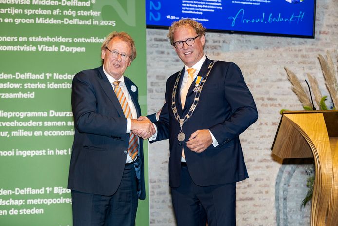 Jaap Smit (links) feliciteert Arnoud Rodenburg met zijn lintje.