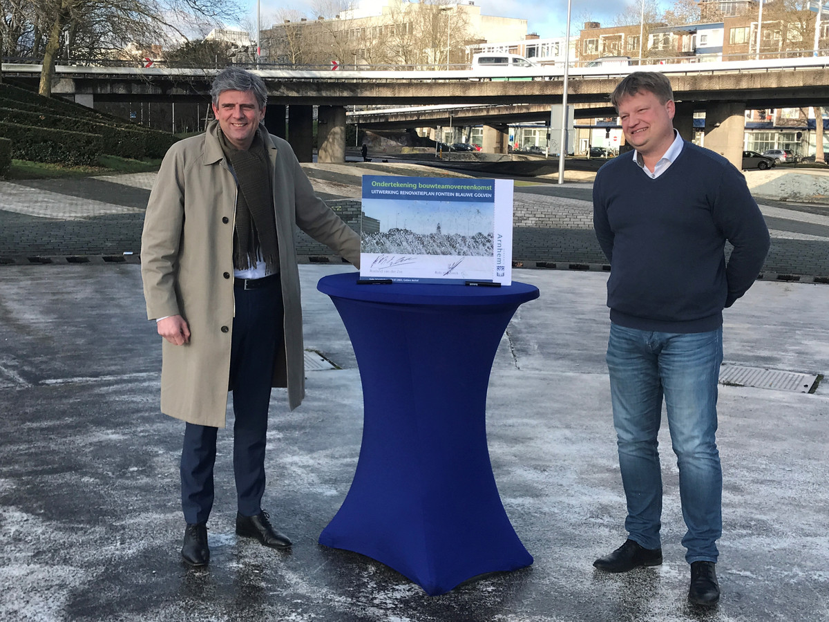 Wethouder Roeland van der Zee (links) en Hugo Rots, directeur van Rots Maatwerk, ondertekenen de overeenkomst in het midden van de fontein op de Blauwe Golven.