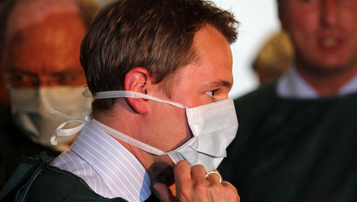 De Duitse minister Daniel Bahr deed gisteren een mondkapje voor voordat hij de intensive care van het ziekenhuis in Hamburg betrad. © ANP Beeld 