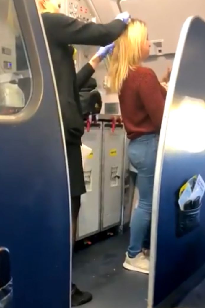 Het haar van de vrouw wordt door een stewardess gereinigd.