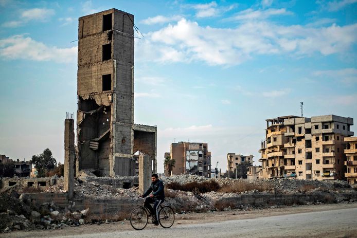 Een fietser rijdt door de in de Syrische oorlog verwoeste stad Raqa in het noorden van het land. Foto ter illustratie.