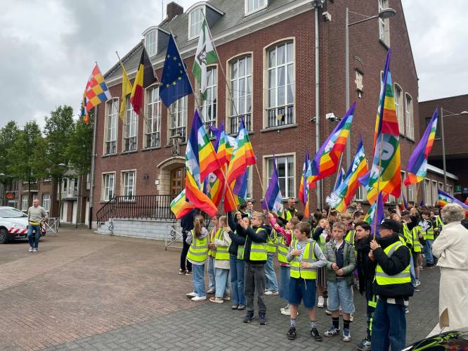Leerlingen trekken met vredesvlaggen door het dorp