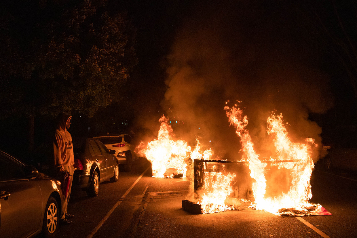 Demonstranten hebben een bank in brand gezet. Beeld AFP
