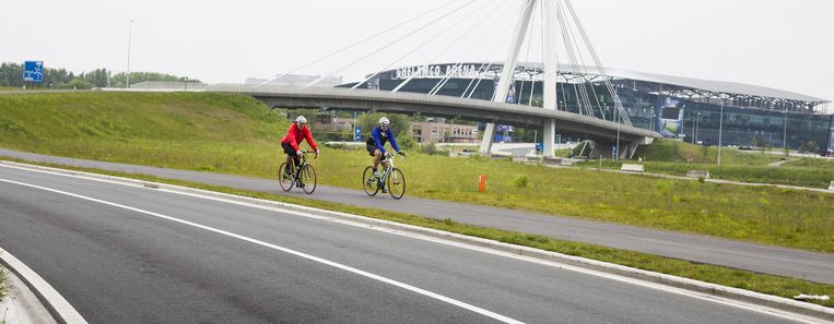 Fietsvrienden Piet en Paul fietsen richting de Schelde, met in de achtergrond de Gentse Ghelamco Beeld Faye Pynaert
