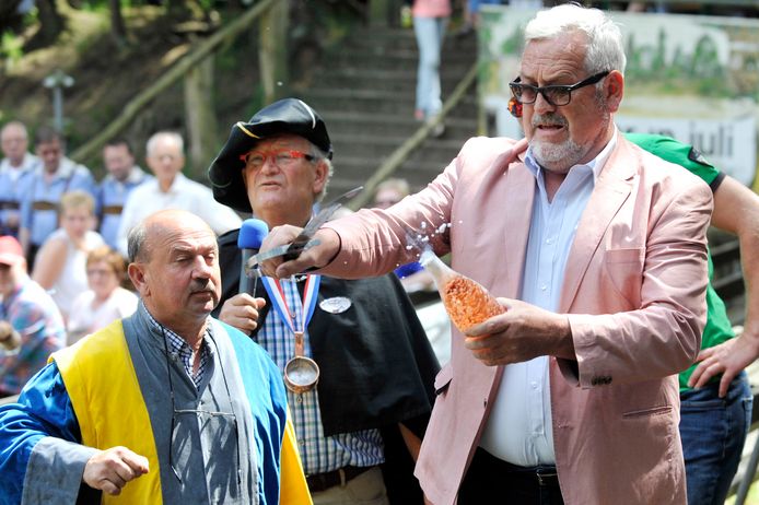 Ernst Daniël Smid slaat tijdens de Internationale Wijnmarkt in Markelo met een sabel de hals van een fles Maarkels Broes.