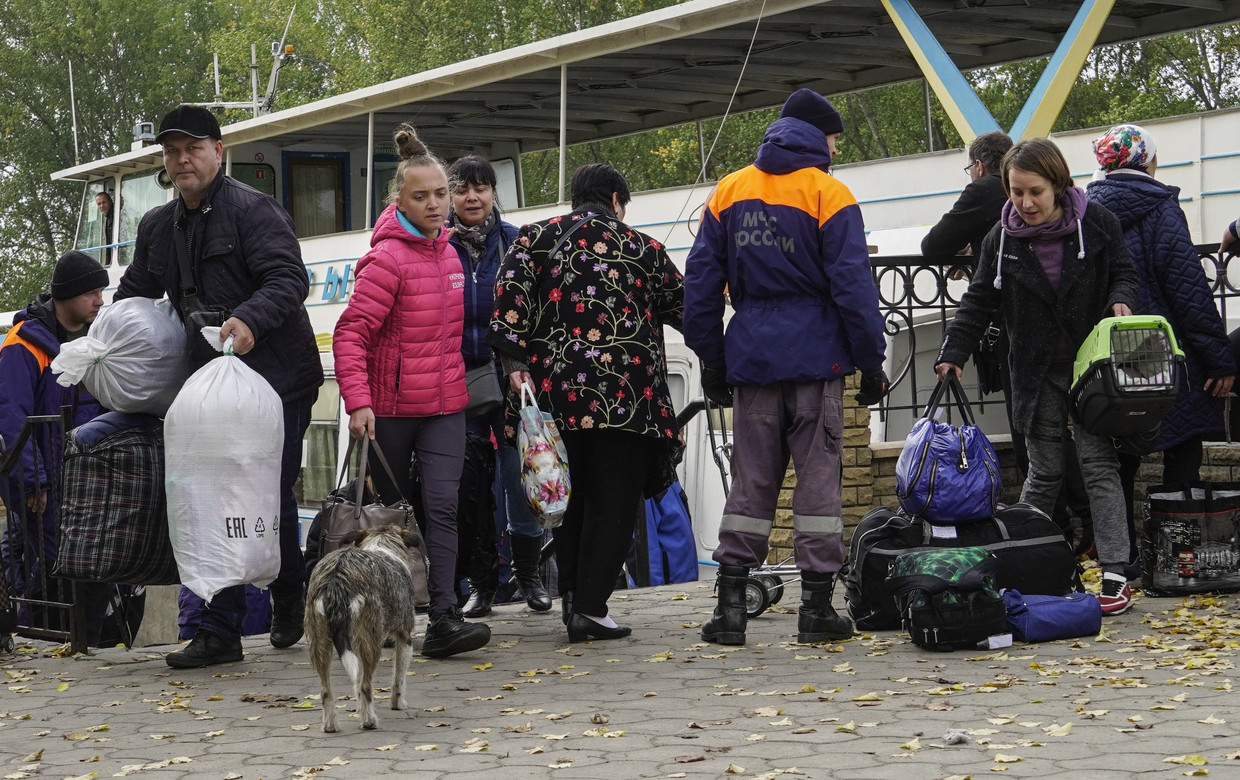 Een groep geëvacueerde burgers uit Cherson na aankomst in het stadje Olesjky, aan de monding van de rivier de Dnipro. De Russische bezetters zijn bezig met een grootscheepse ontruiming van Cherson, mogelijk met het oog op een naderende stadsoorlog. Beeld ANP / EPA