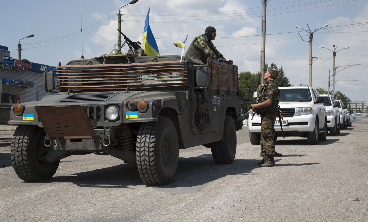 Oekraïnse militairen bij de colonne van OVSE-voertuigen. Vandaag liet het Oekraïense leger de OVSE door, waardoor de verkenners van de organisatie eindelijk de plek waar MH17 neerkwam konden bereiken. Beeld ap