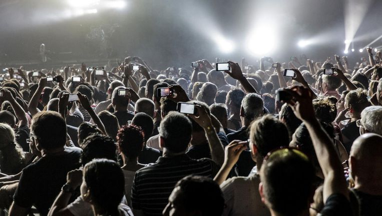 Een vertrouwd beeld bij concerten: een menigte met daarboven een wolk van schermpjes. Beeld Getty Images  