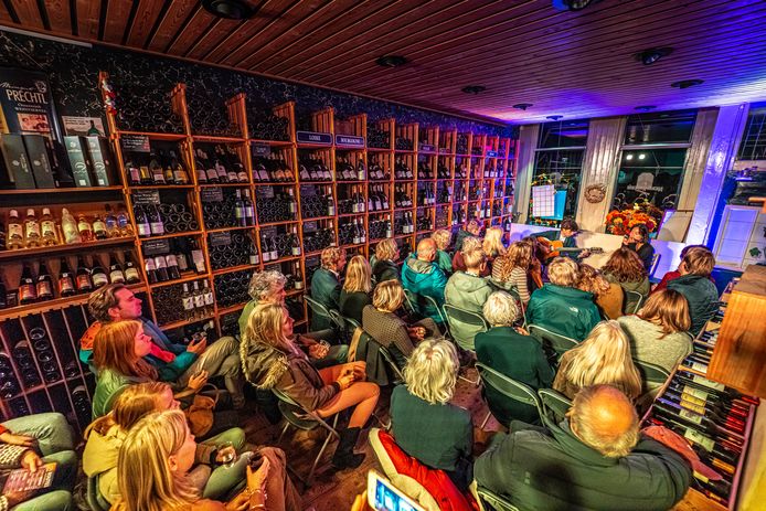 Publiek geniet van de muziek tussen de wijnflessen in wijnkoperij Bloem.