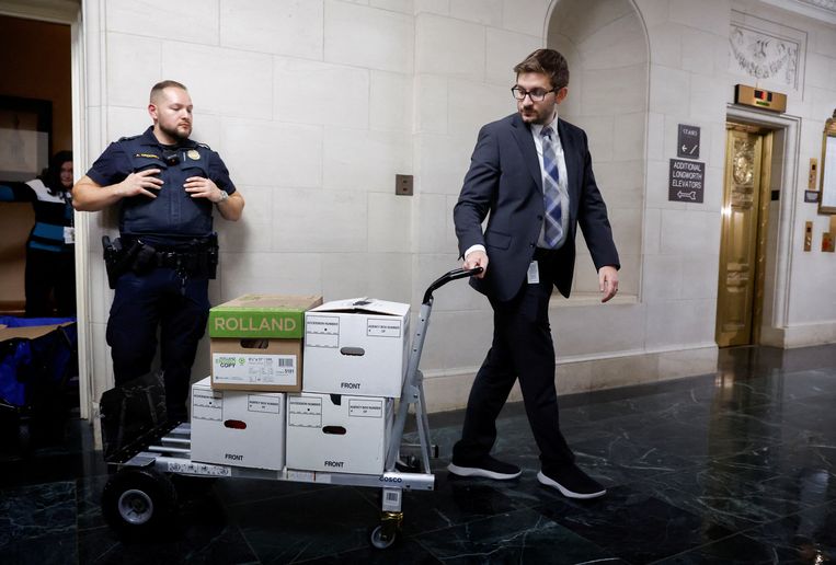 Medewerkers van de commissie van het Huis van Afgevaardigden vervoeren dozen met documenten na een vergadering over de belastingaangifte van voormalig president Donald Trump te bespreken op Capitol Hill in Washington. Beeld REUTERS