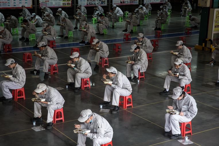 Werknemers eten hun lunch op twee meter afstand van elkaar.  Beeld Getty Images