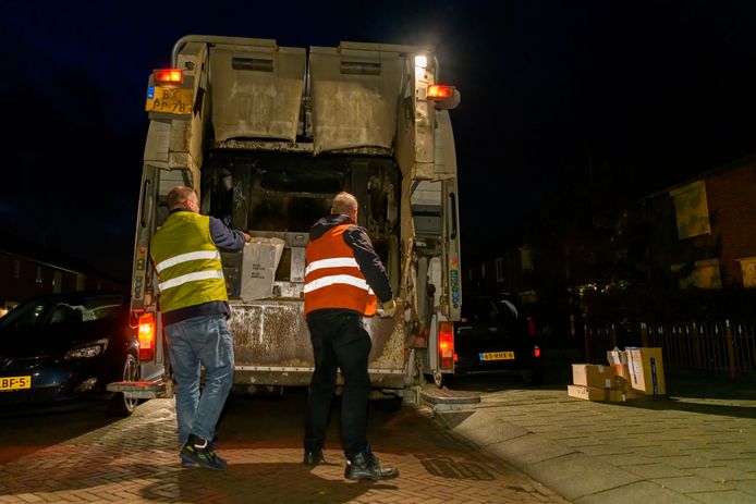 Vrijwilligers halen oud papier op  in Sprang-Capelle. Links Frans Eikelenboom, rechts BD-verslaggever Michel Koster.