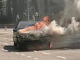 De voorkant van de auto staat in lichterlaaie op de kruising van de Velperweg en de Bronbeeklaan in Arnhem.