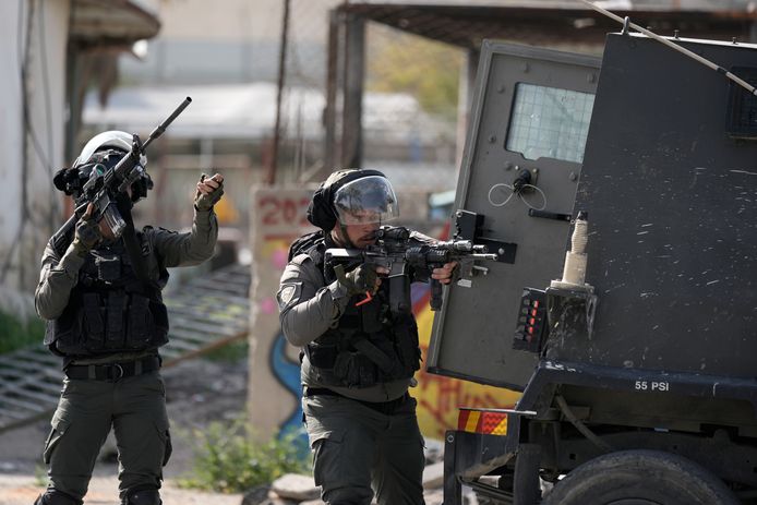 Israelische soldaten richten hun wapens op Palestijnen bij de ingang van het vluchtelingenkamp Aqabat Jaber nabij Jericho op de bezette Westelijke Jordaanoever.