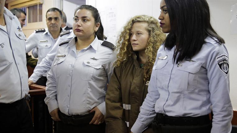 De 16-jarige Palestijnse Ahed Tamimi wordt gehandboeid naar de rechtszaal gebracht. Beeld ap