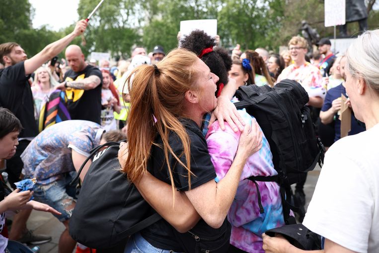 Twee mensen in een innige omhelzing, op een Londens protest tegen de maatregelen.  Beeld REUTERS