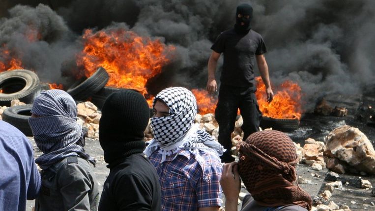 Libanese soennitische moslims blokkeren uit protest een weg met verbrande banden. Beeld reuters