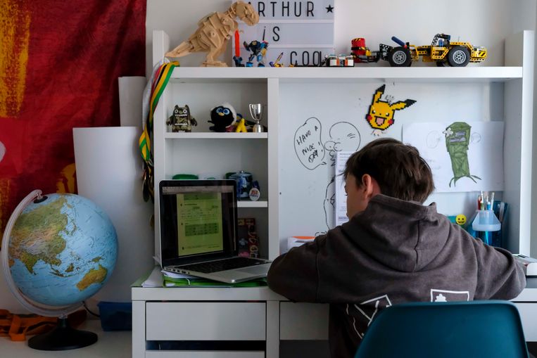 Een courante situatie in talloze Vlaamse huishoudens de afgelopen maanden: een leerling volgt les op zijn kamer.  Beeld BELGA