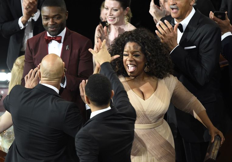 Common en John Legend krijgen een 'high five' van acteur David Oyelowo en Oprah Winfrey. Beeld AFP