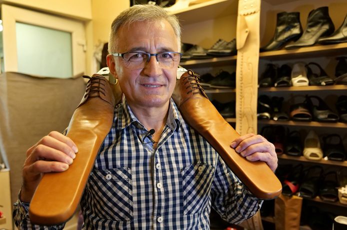 De Roemeense schoenmaker Grigore Lup poseert met een paar social distancing-schoenen.
