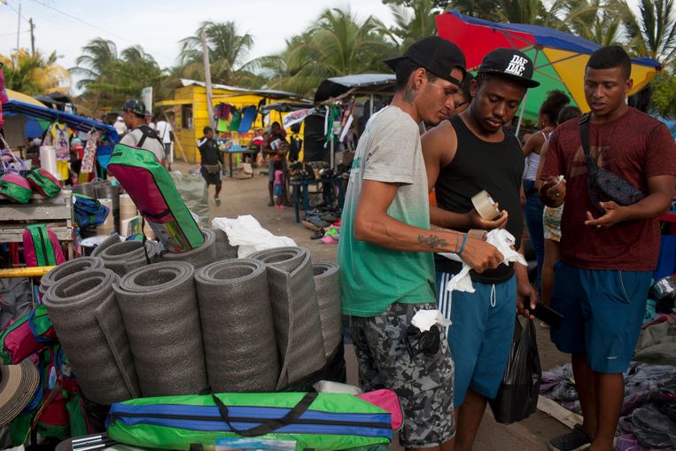 De 'zeedijk' van Necocli is een soort supermarkt geworden voor Haïtianen die proviand en andere spullen nodig hebben voordat ze aan de loodzware oversteek beginnen.  Beeld Carlos Villalon
