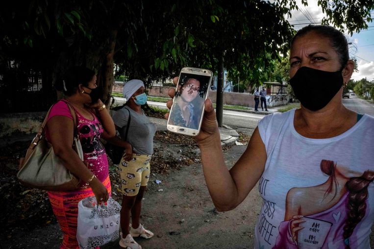 Yaquelin Cruz laat een foto zien van haar zoon Dariel Cruz, die werd gearresteerd tijdens de protesten in juli vorig jaar.  Beeld AP