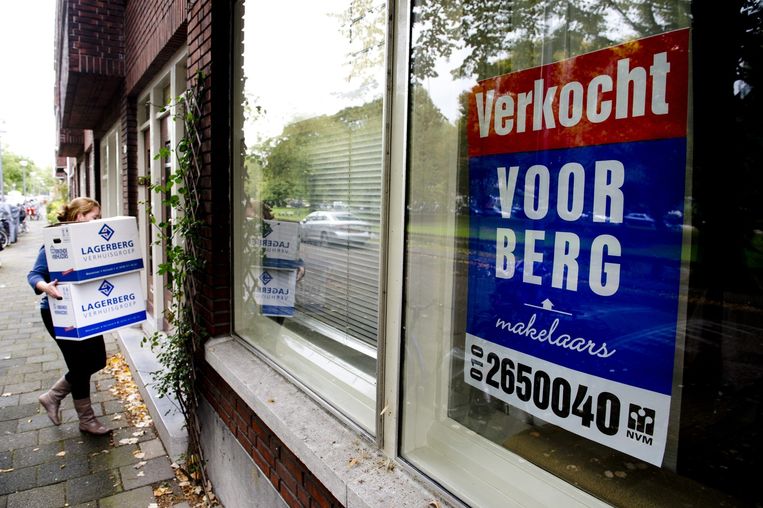 Een vrouw draagt verhuisdozen haar nieuwe huis in Rotterdam in. Beeld anp