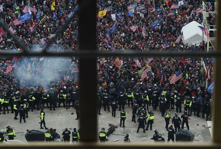 Agenten proberen Trump-aanhangers tegen te houden bij het Capitool.  Beeld AFP
