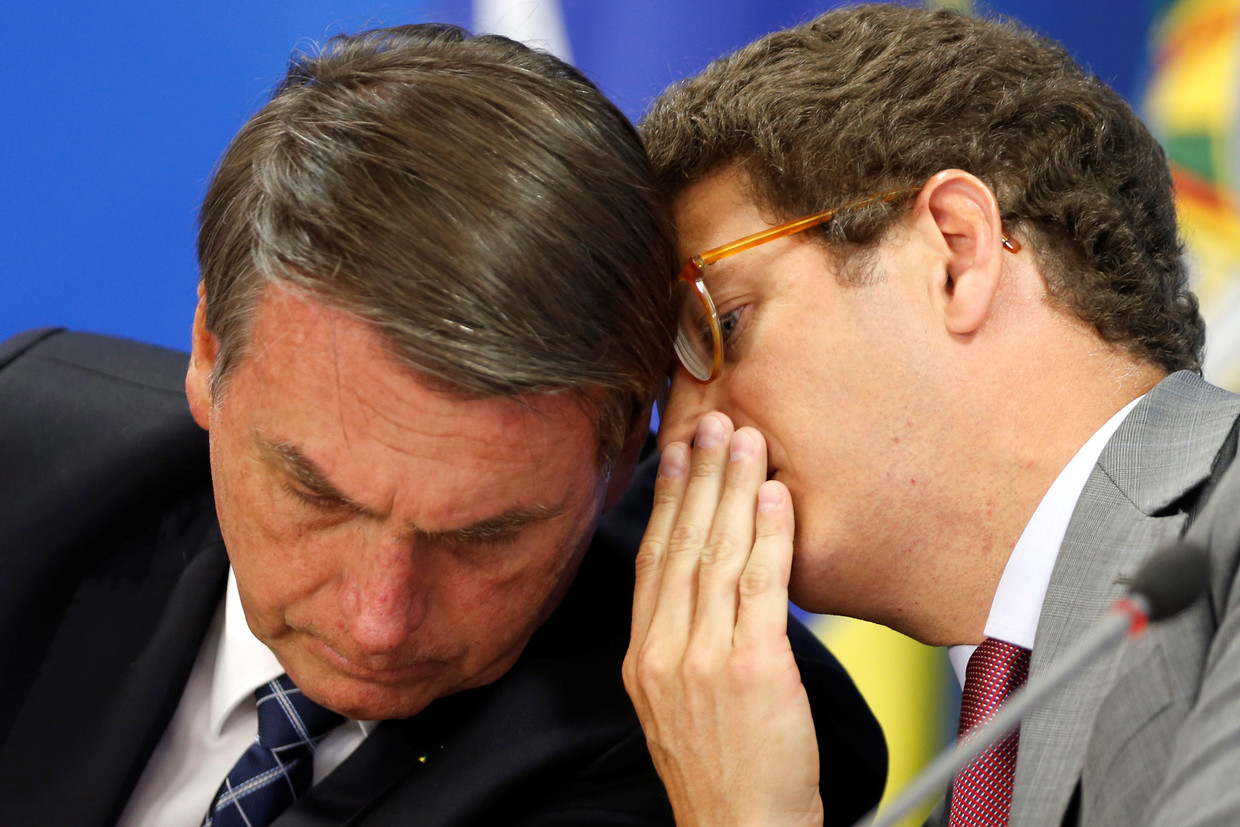 De Braziliaanse president Jair Bolsonaro (links) in een onderonsje met milieuminister Ricardo Salles. Beeld REUTERS