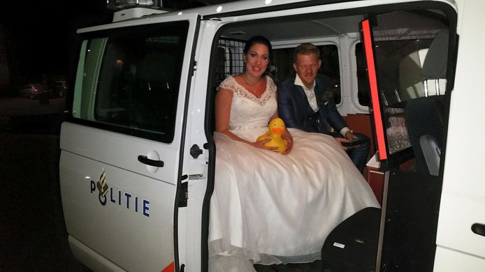 Het bruidspaar in de politieauto.