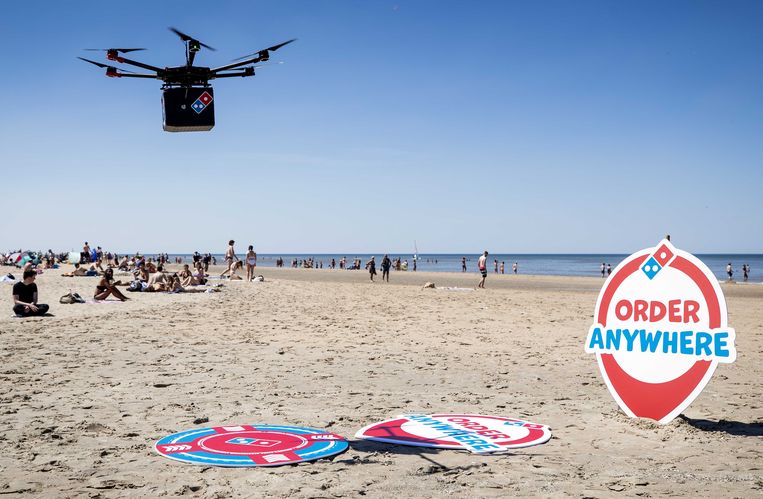 2020: een drone met daaronder een box om pizza’s in te voeren tijdens een test op het strand van Zandvoort. Pizzaketen Domino’s wil pizza’s gaan bezorgen met drones.  Beeld ANP
